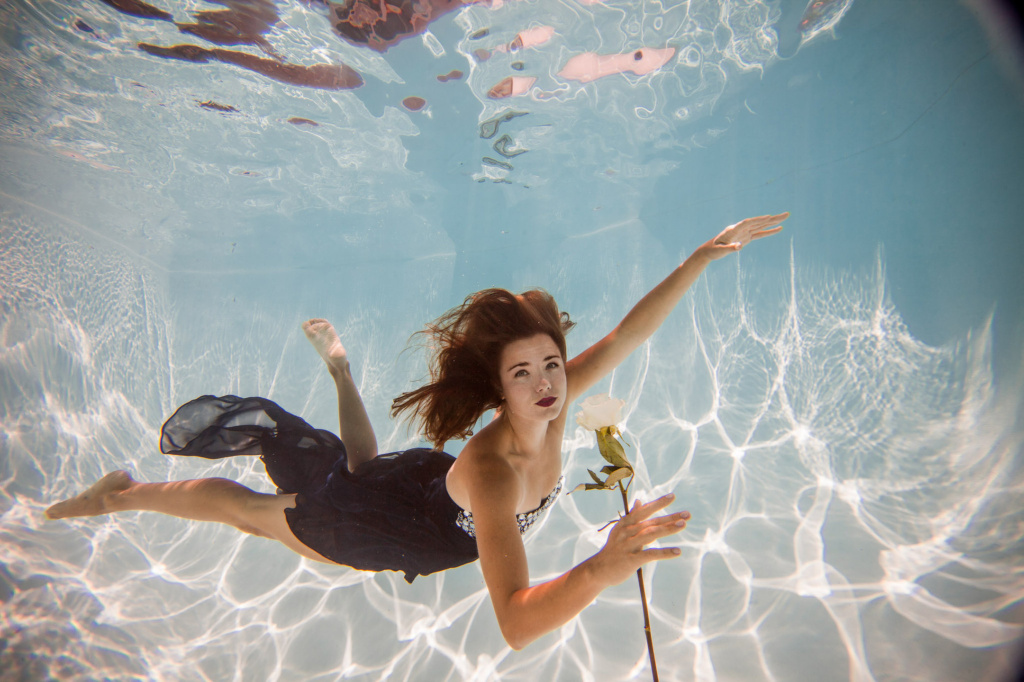 Underwater Model in Black Dress With White Rose